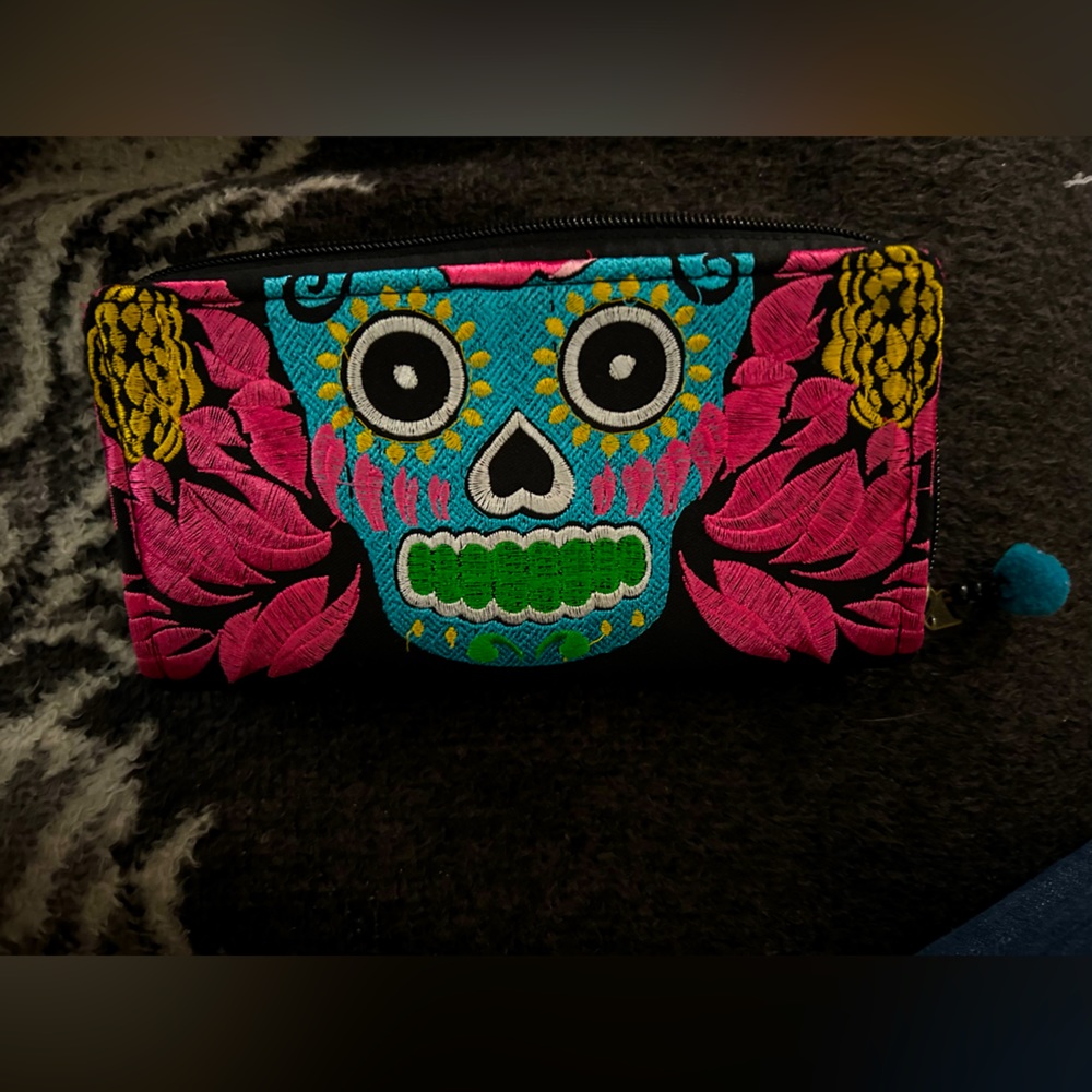 Blue skull with beautiful pink, yellow, green, white, and yellow design.